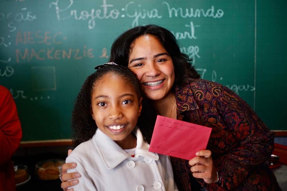 A volunteer hugging a student at Projeto Gira Mundo