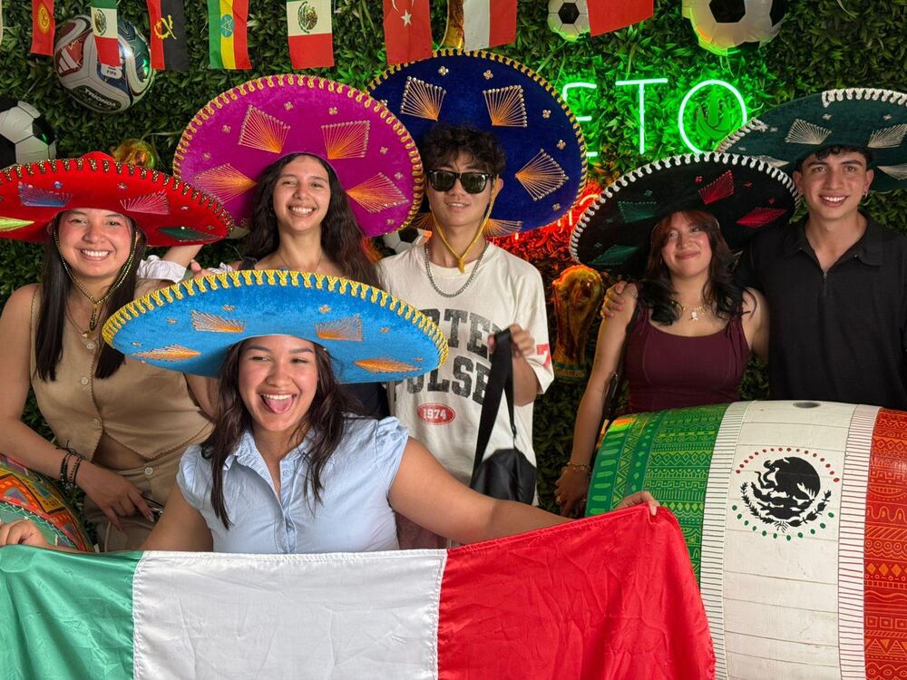 Exchange participants celebrating in Mexico with sombreros and a Mexican flag