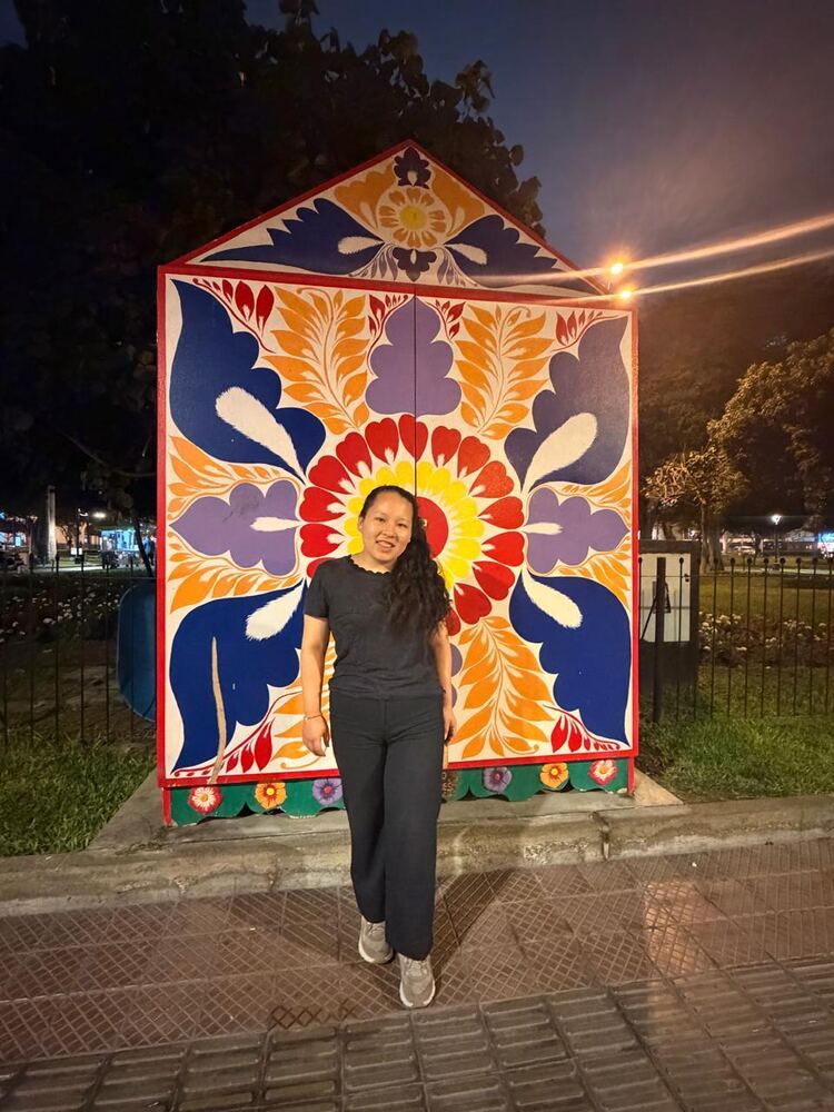 An exchange participant in front of a colorful painted mural